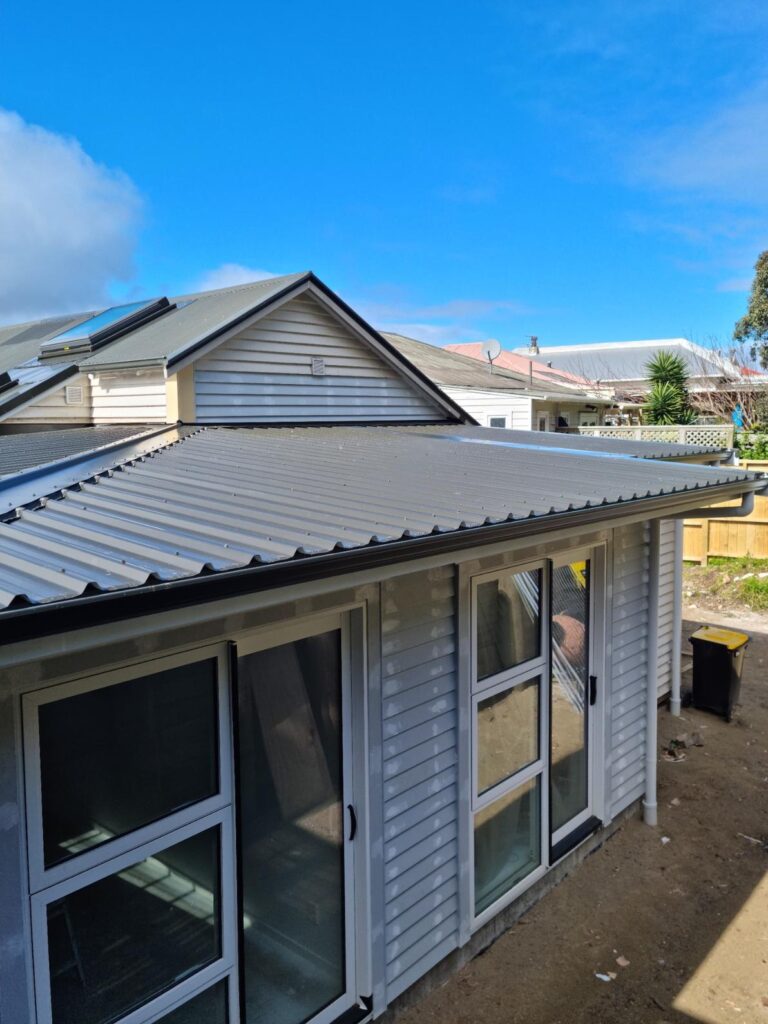 Completed home extension in Wellington with new roofing, windows, and cladding under clear sky