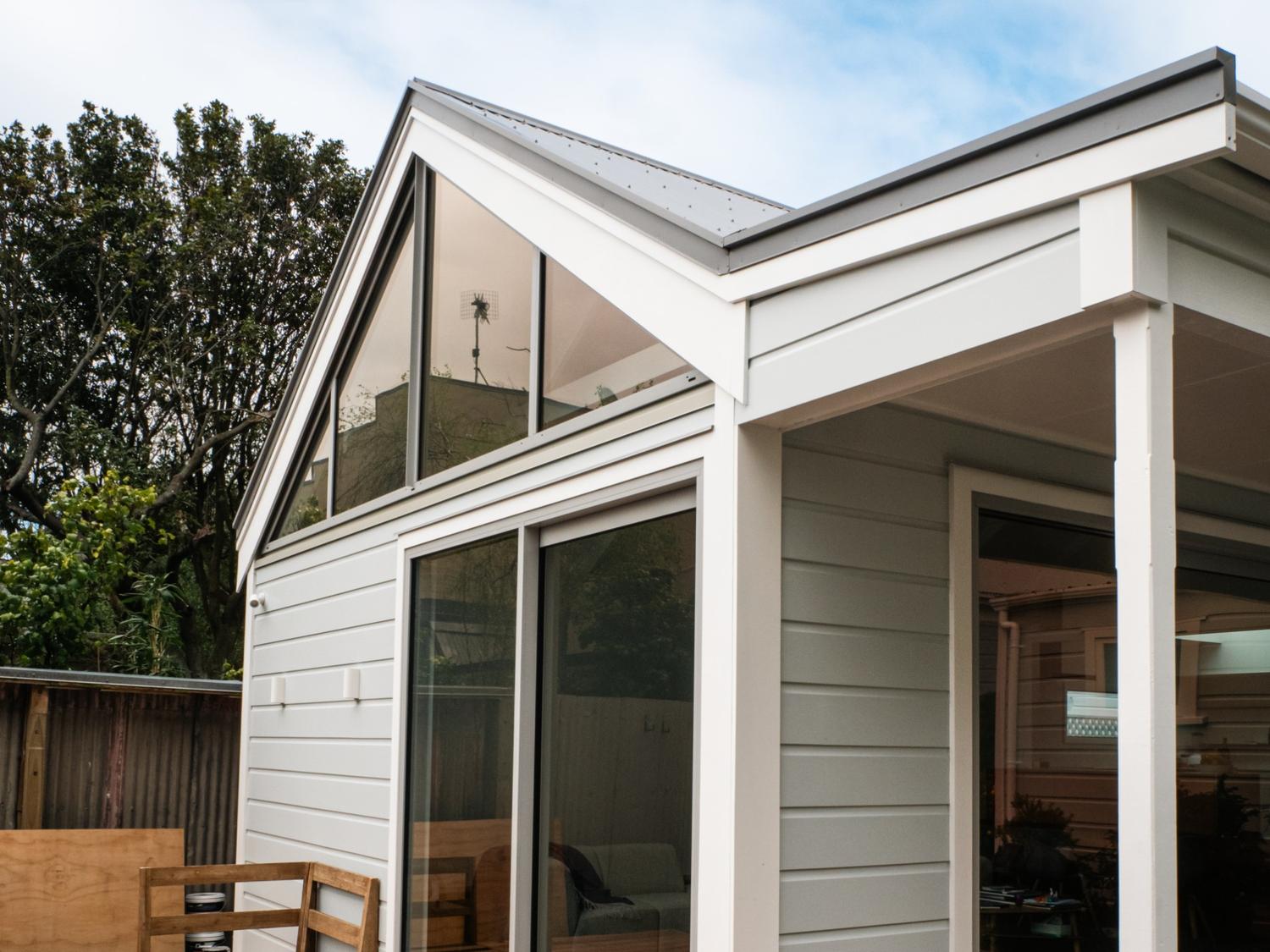 Exterior view of the renovated 1901 villa in Thorndon, Wellington by Clearcut Building Solutions, featuring restored weatherboards, gable windows, and modern sliding doors.