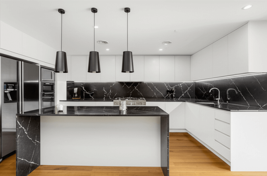 Beautifully renovated modern kitchen in Porirua with stone benchtops and pendant lighting