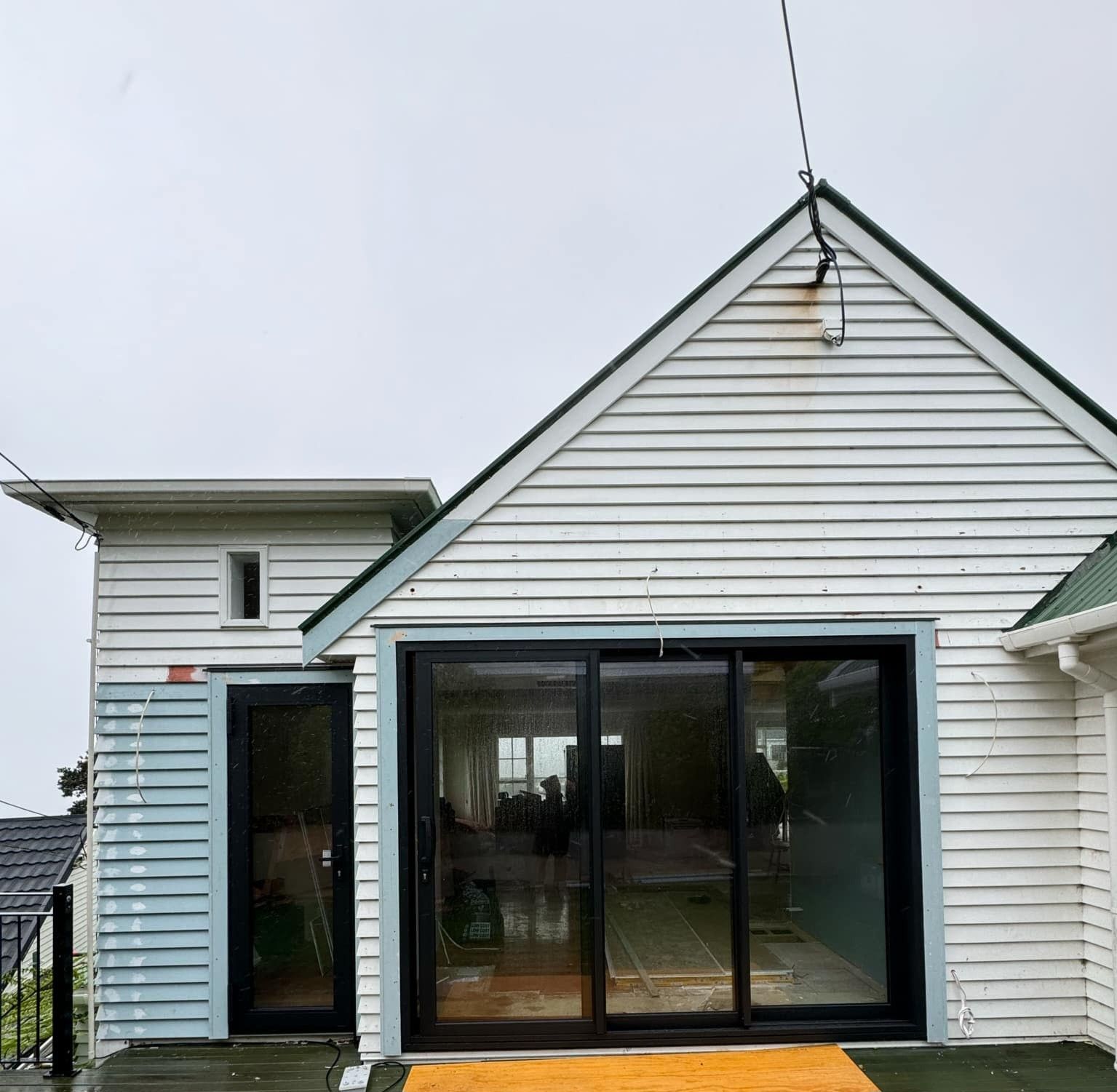 Wellington home mid-recladding showing exposed framing and new cladding installation for code compliance by Clearcut Building Solutions